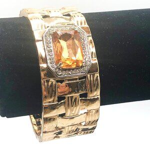 Gold tone lattice clamper bracelet with amber glass stone rhinestone halo